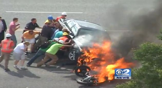 Bystanders LIFT a burning car to save trapped&nbsp;motorcyclist