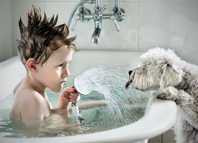 Dog-getting-drink-from-boy-in-tub