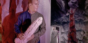 A behind-the-scenes photo of Captain Kirk holding a rather phallic stalactite.