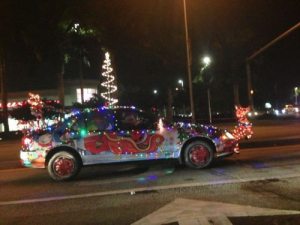 Car painted and decorated to look like Santa's sleigh and has a Rudolf lawn ornament on the front of the grill.