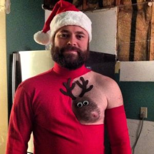 Hairy-chested man shaved chest to look like a reindeer. Nipple is the nose.