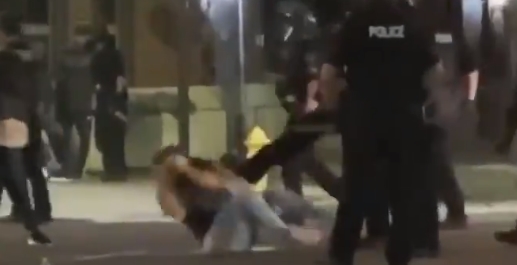 Girl on the ground being kicked by police during&nbsp;protests